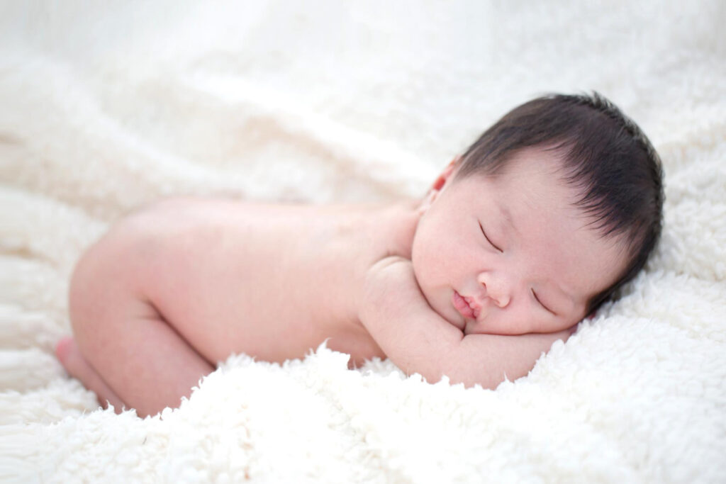 Asian baby sleeping on a furry blanket